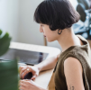 Team member working at a computer, managing multilingual content for a TRIMIT e-commerce site.