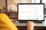 Person arbeitet am Laptop mit dem TRIMIT Sales Agent Dashboard zur Verwaltung von Aufträgen, Kunden und Vertriebsstatistiken.
